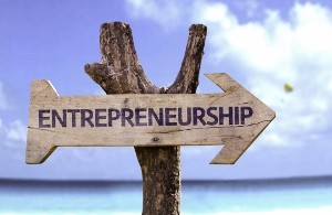 Entrepreneurship wooden sign with a beach on background
